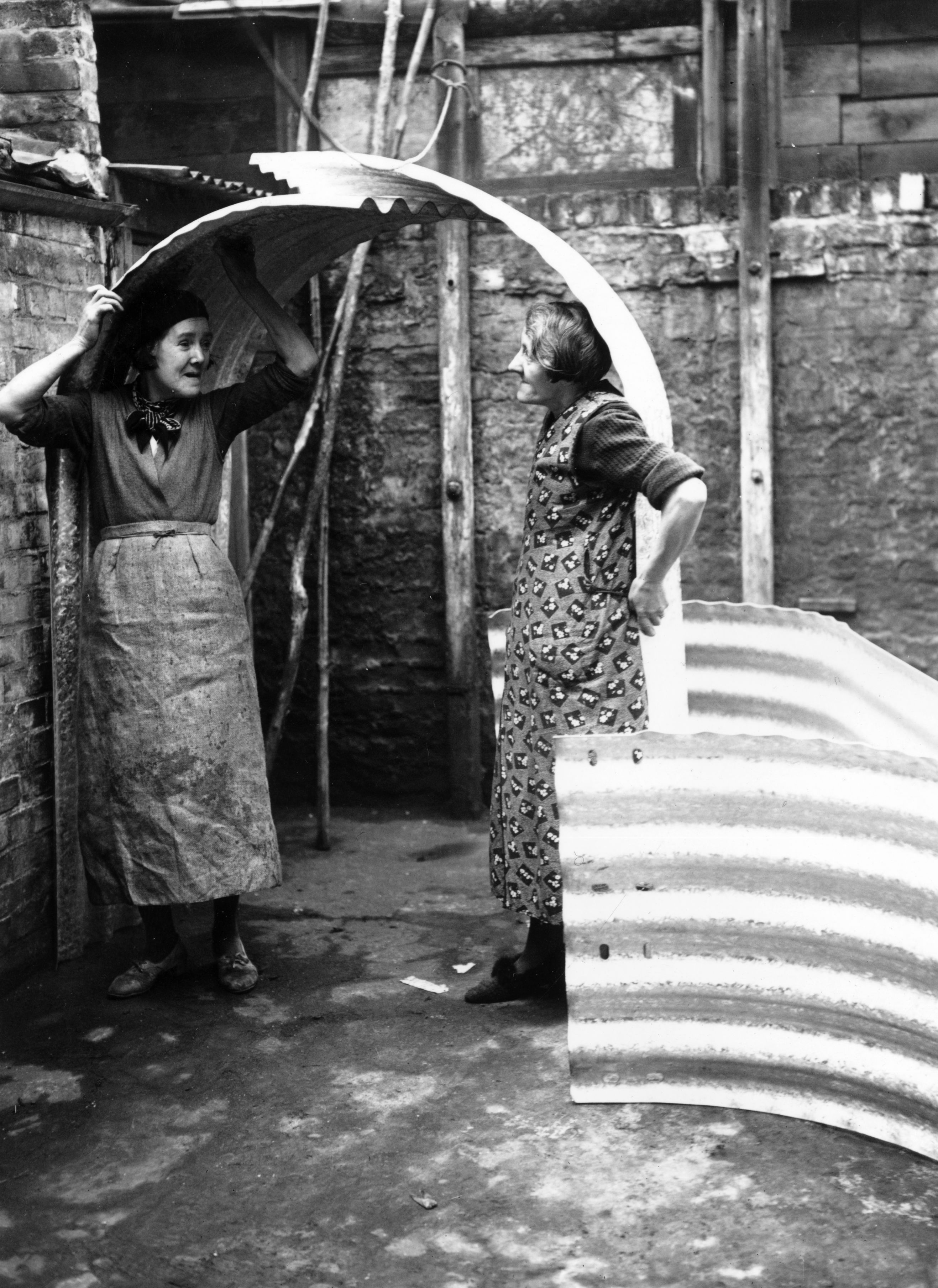 Two women in Islington, London, try out the height of their new air raid shelter Two women in Islington, London, try out the height of their new air raid shelter