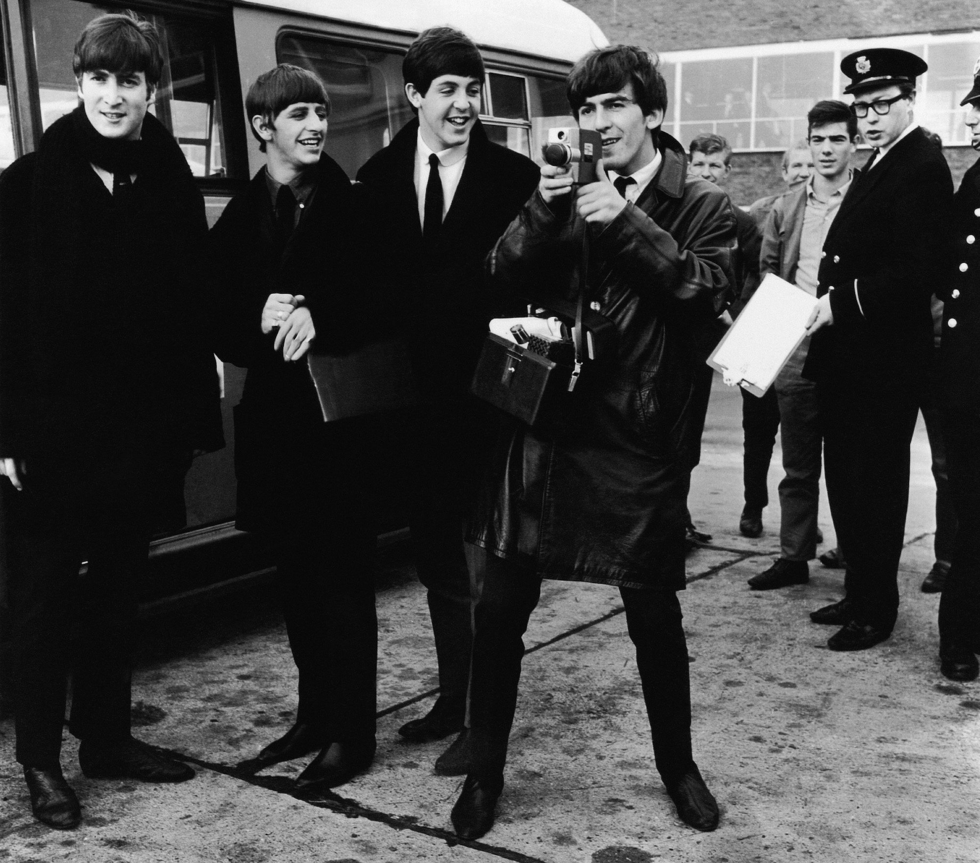 The Beatles about to climb onto a bus at London Airport