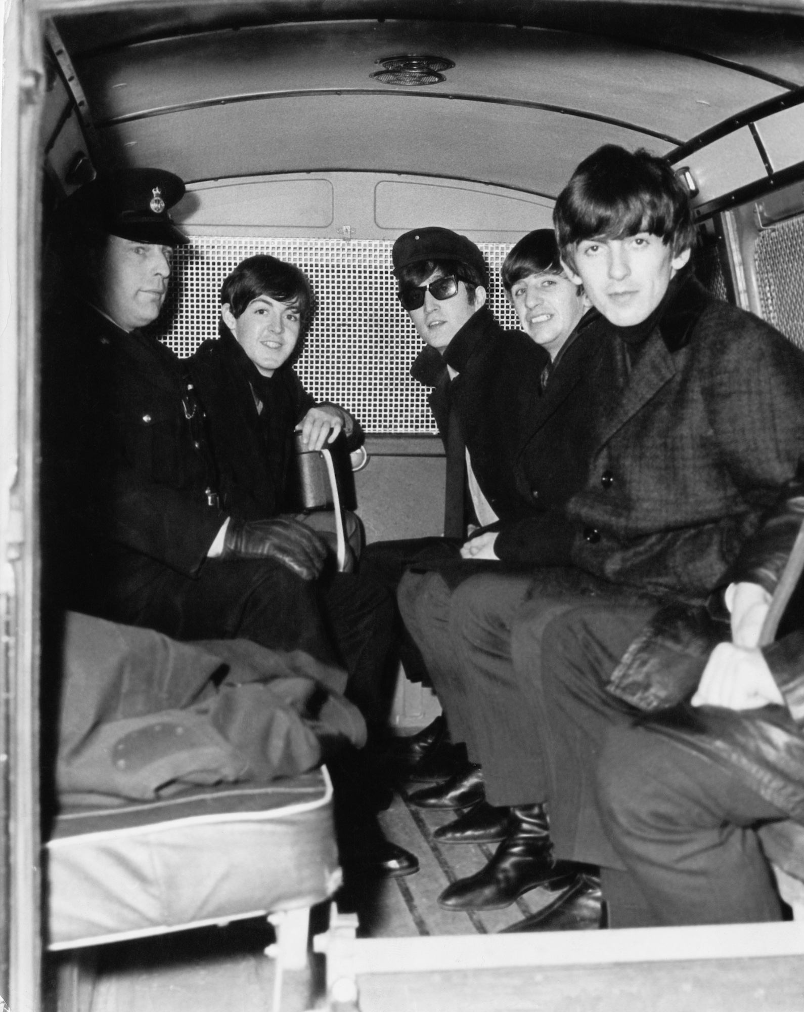 The Beatles travelling, for their own security, in the back of a police van