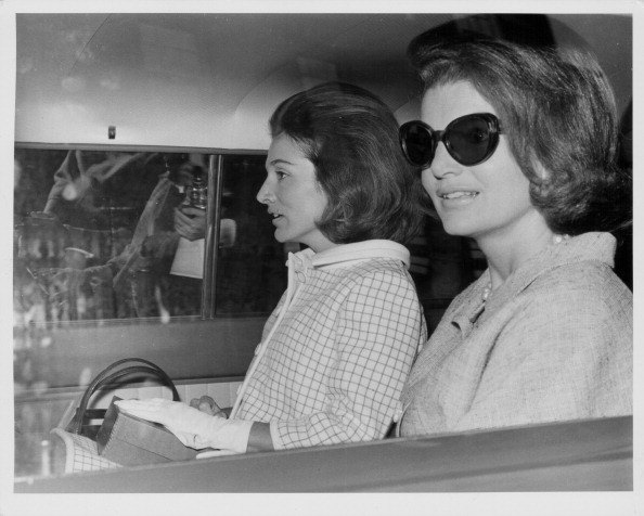 Sisters and socialites Princess Lee Radziwill and Jacqueline Kennedy, sitting in the back of a car in London, May 15th 1965