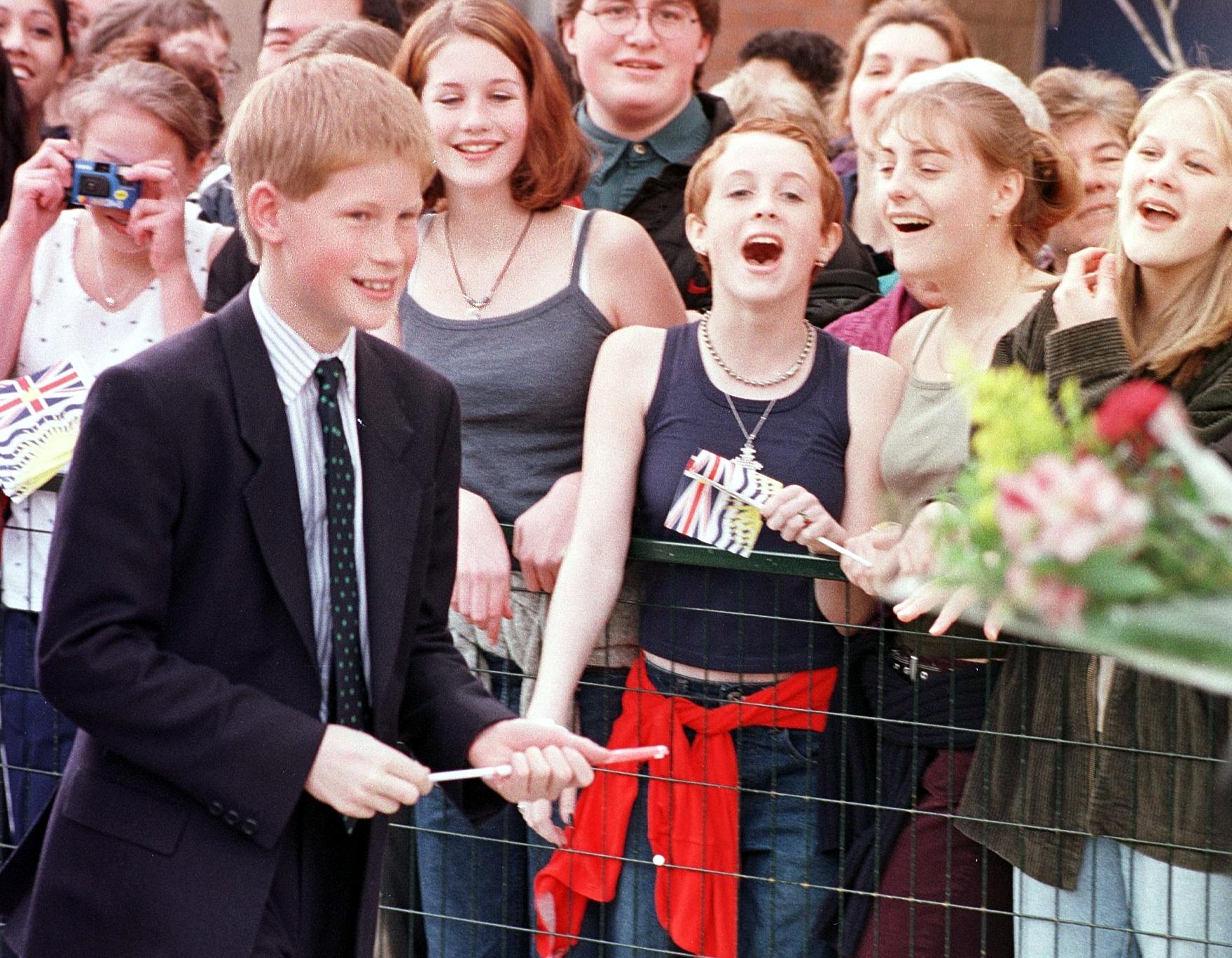  Prince Harry walks past cheering teenage girls into Burnaby High School 24 March in Vancouver. Princes Charles and his two sons William and Harry are in Canada for a six day visit which will combine official engagements with a royal skiing holiday.