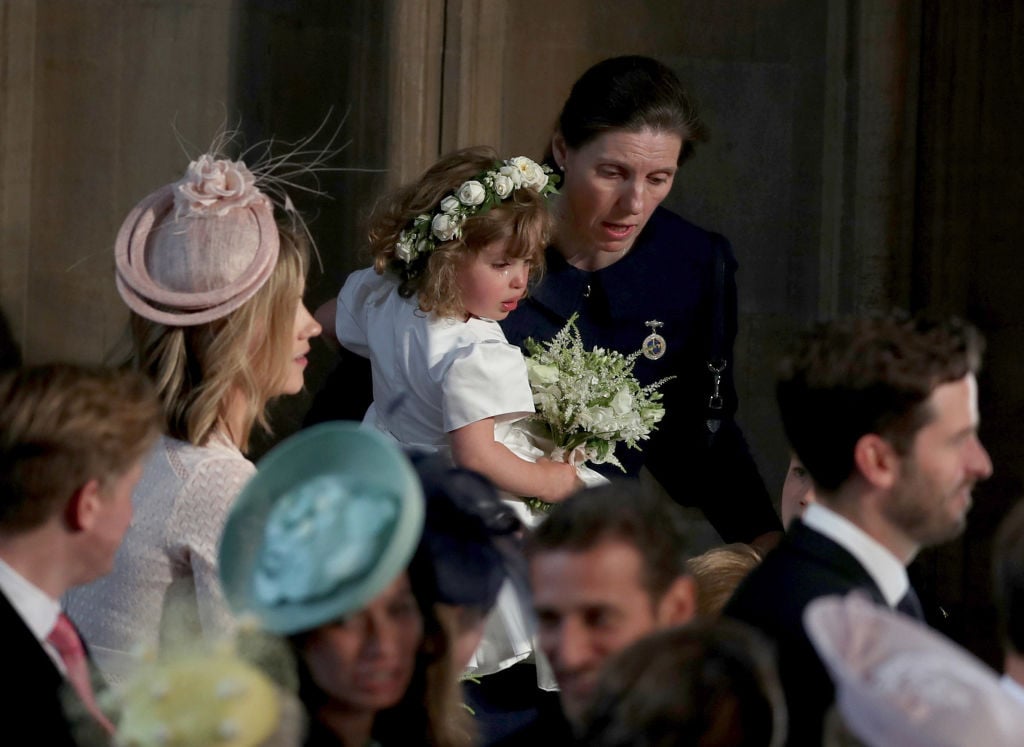 Royal Nanny Maria Teresa Turrion Borrallo comforts bridesmaid Zalie Warren inside the entrance to the chapel before the wedding of Prince Harry to Meghan Markle in St George's Chapel at Windsor Castle on May 19, 2018 in Windsor, England