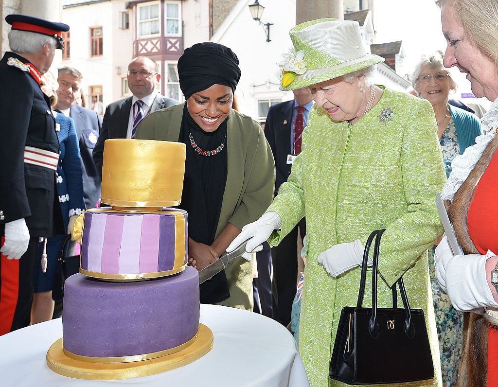 Queen Elizabeth II receives a birthday cake from Nadiya Hussain, winner of the Great British Bake Off, during her 90th Birthday