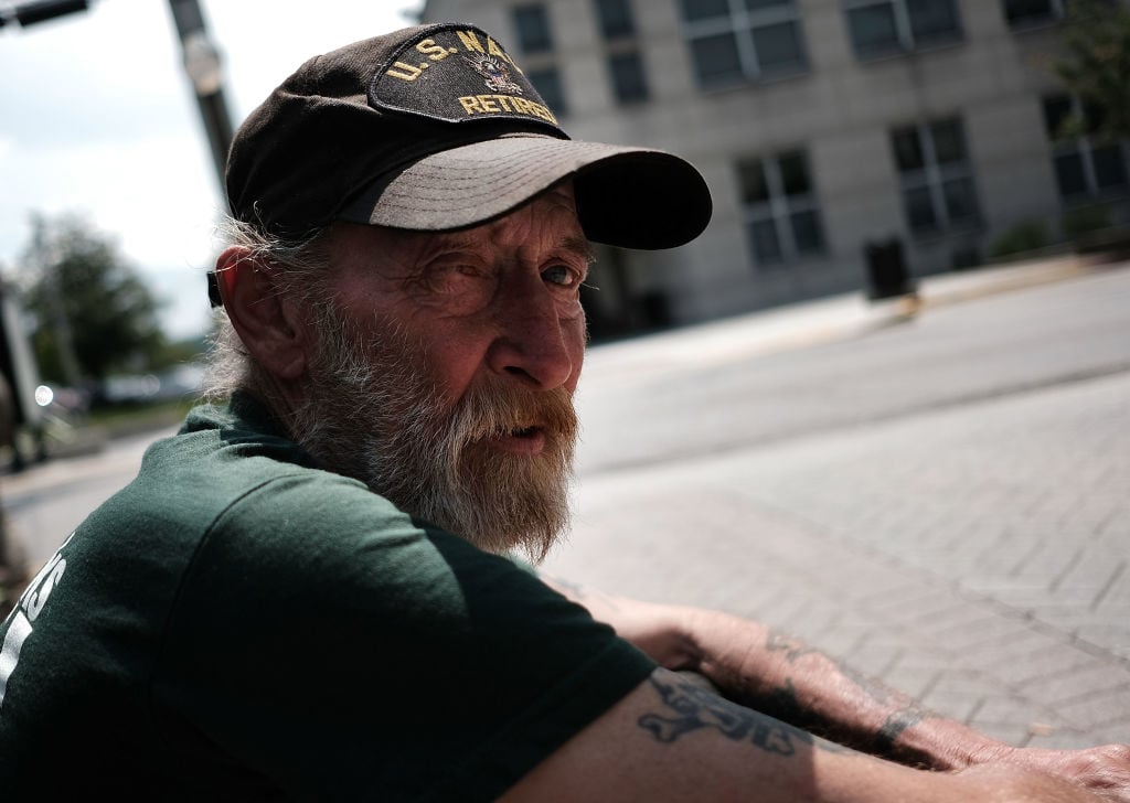 A homeless veteran sits on the streets