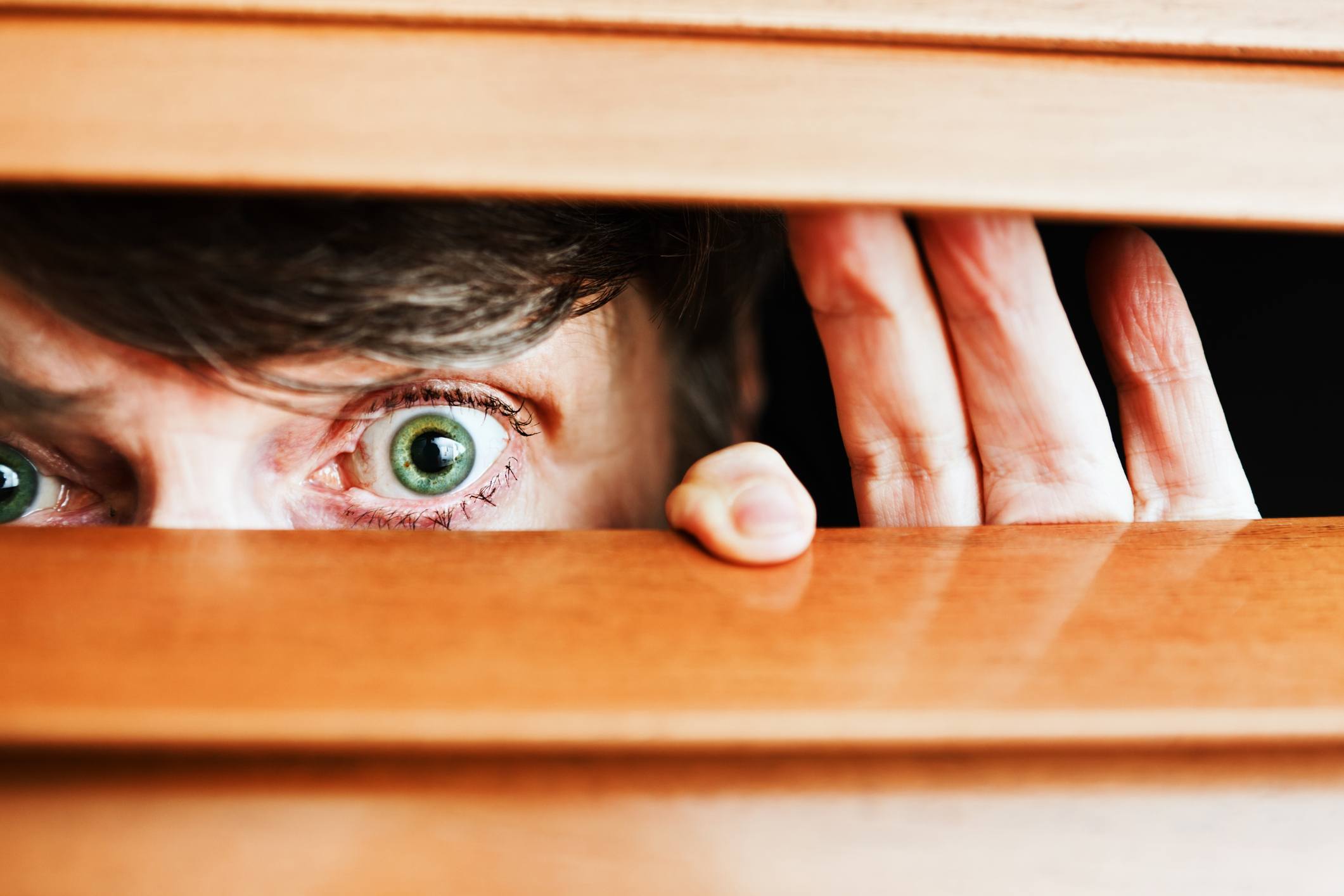Nosy neighbor peeking through blinds