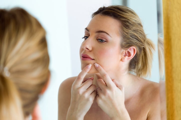 Young woman looking in the mirror