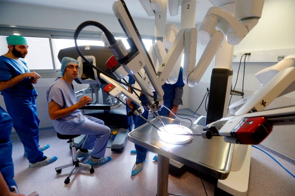 Surgeon sitting with a surgical robot