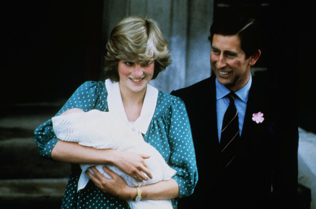 Prince Charles and Princess Diana hold Prince William on the steps of the Lindo Wing at St. Mary's Hospital after his birth.