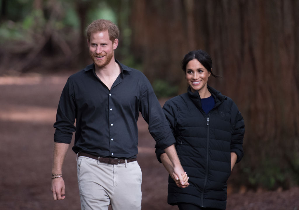 Prince Harry and Meghan Markle walking in the woods together.