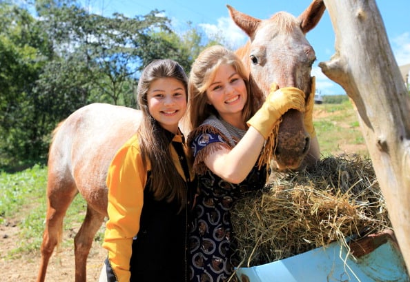 Tori (left) and Erin Bates tend to the horses