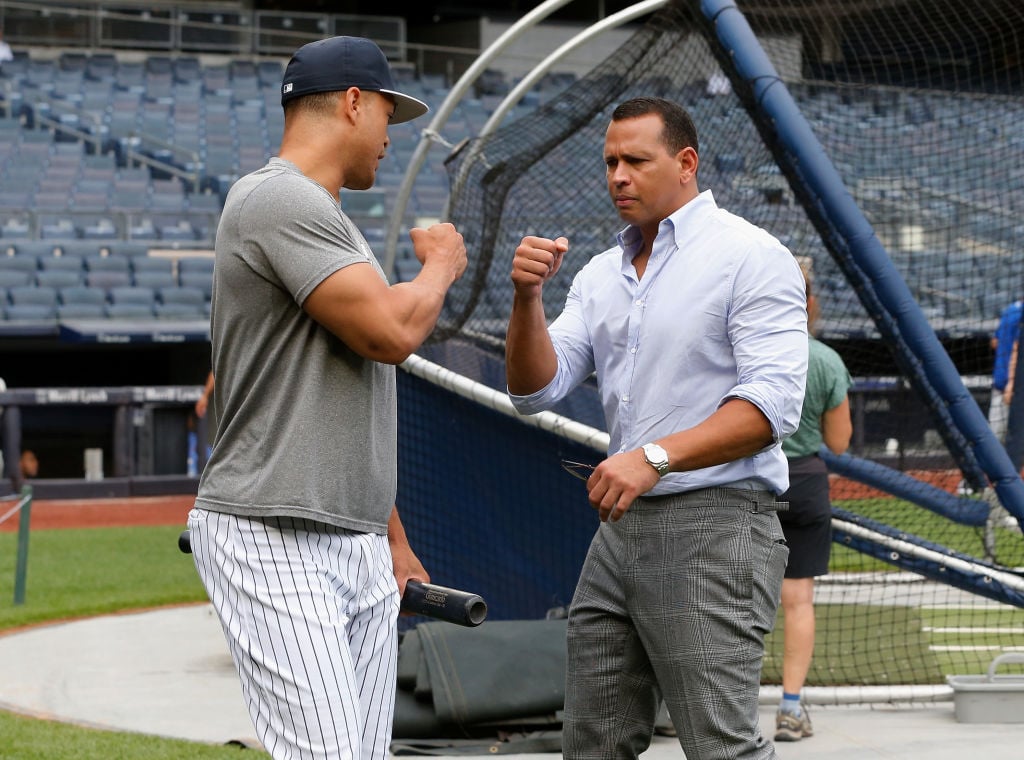 Giancarlo Stanton #27 of the New York Yankees talks with Alex Rodriguez | Jim McIsaac/Getty Images