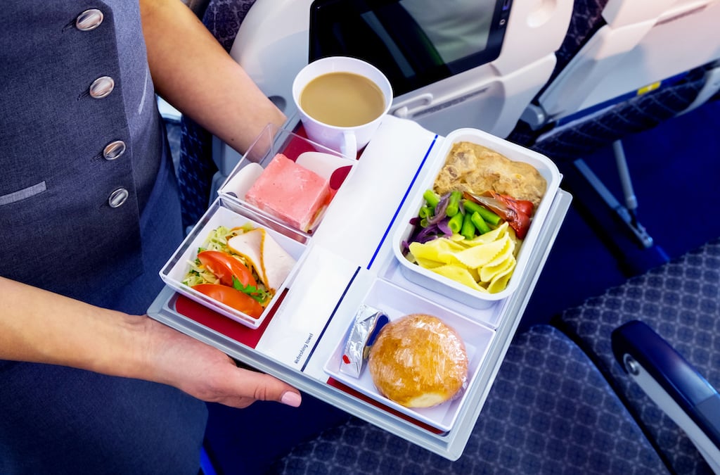 A flight attendant serves a meal
