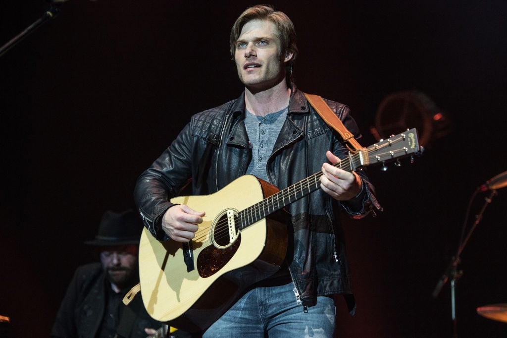 Chris Carmack on stage with a guitar