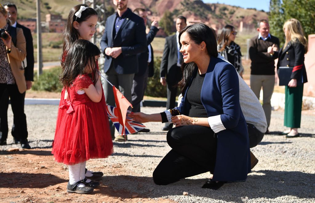 Meghan Markle talks to two girls the henna design on her hand after a visit to the 'Education For All' boarding house in Asni Town, Atlas Mountains on the second day of her tour of Morocco with Prince Harry.
