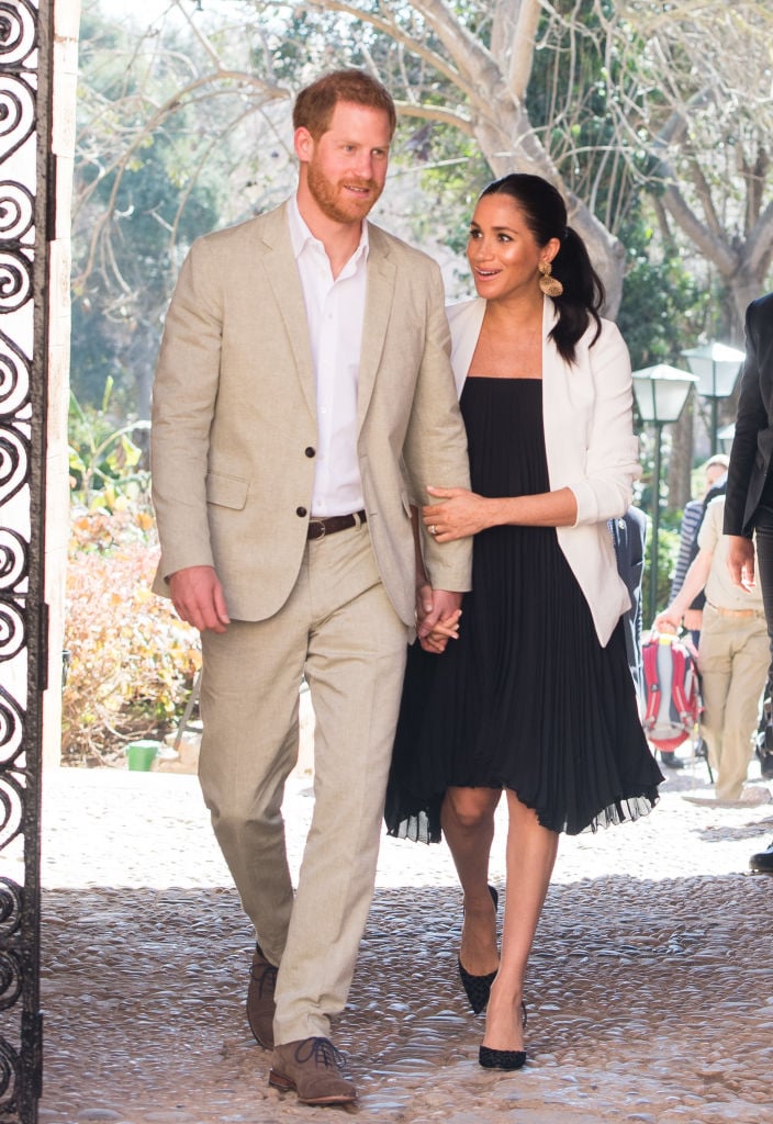 Prince Harry and Meghan Markle hold hands while visiting the Andalusian Gardens in Morocco.