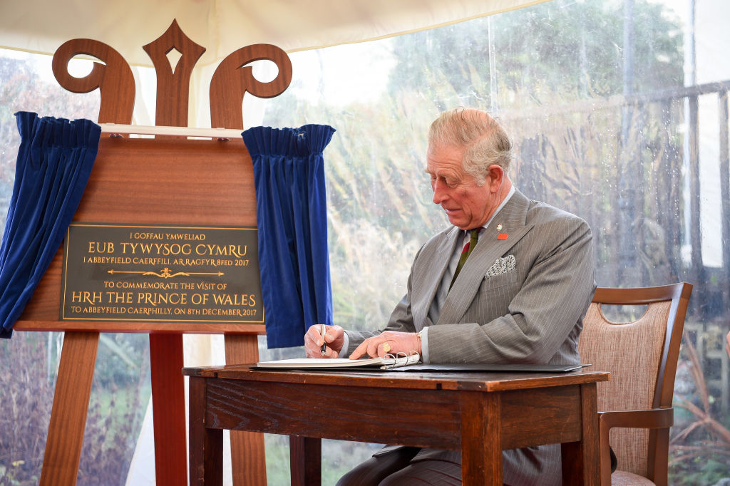 Prince Charles signing a visitors book