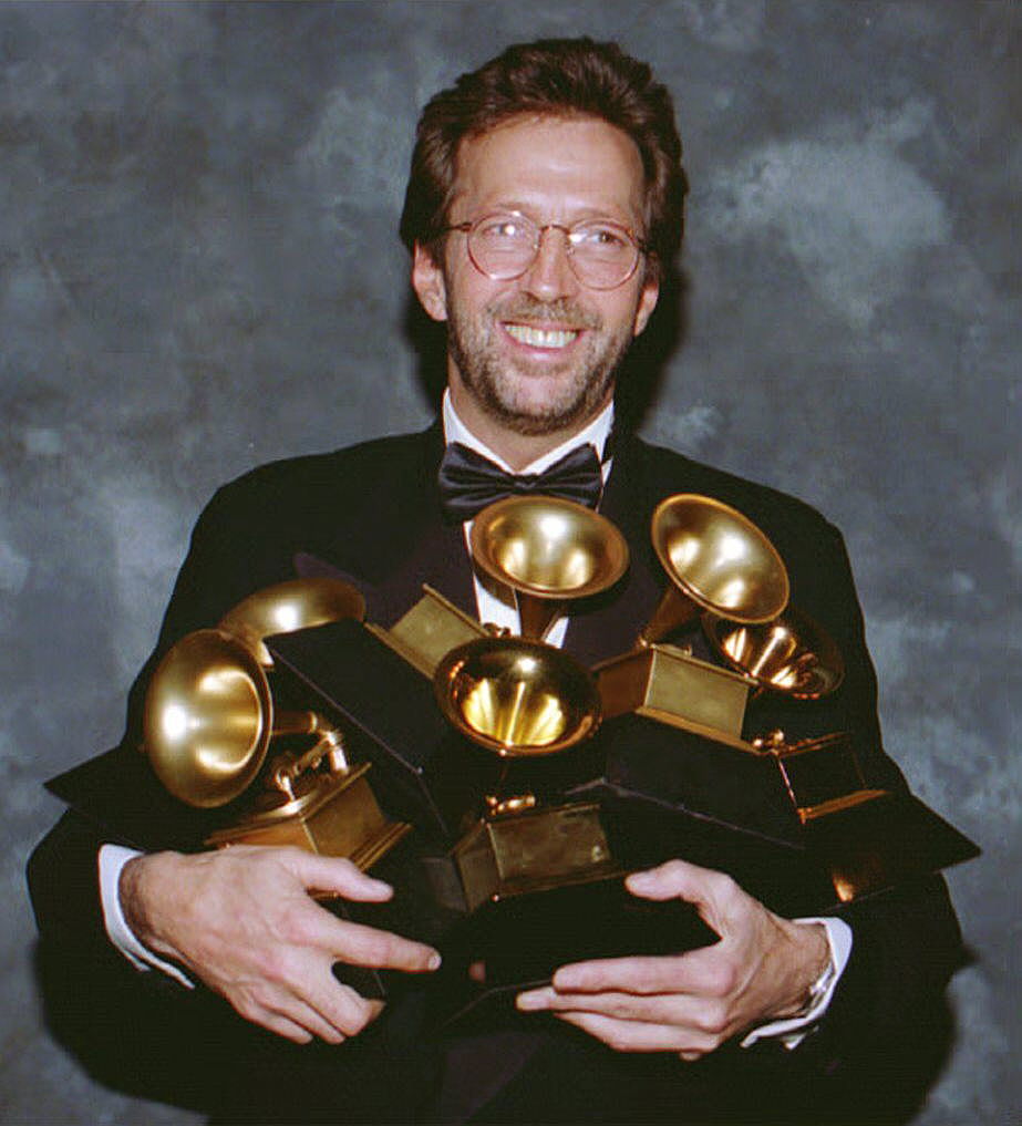 Eric Clapton cradles his six Grammy Awards and poses for a picture