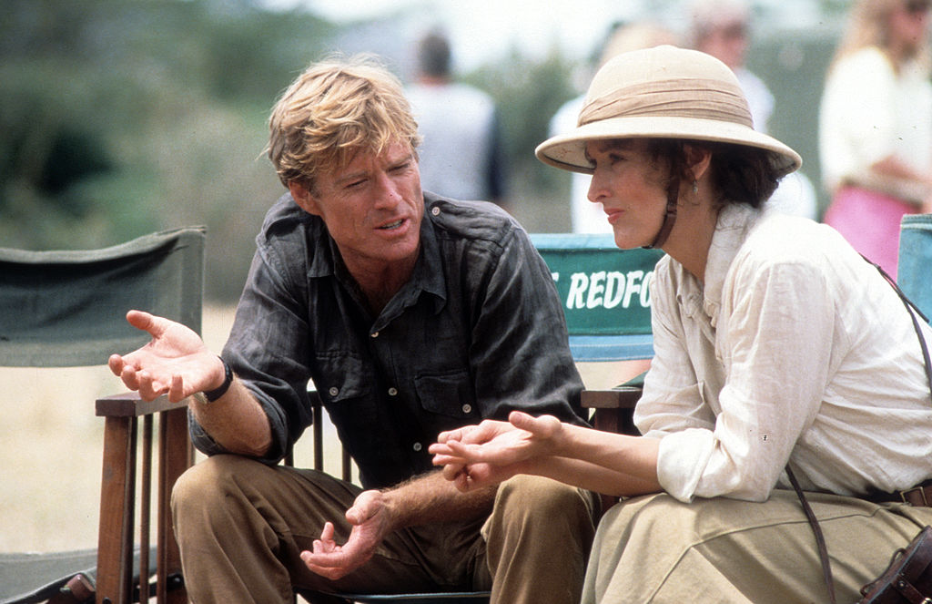 Meryl Streep and Robert Redford sit and talk together on the set of Out of Africa.