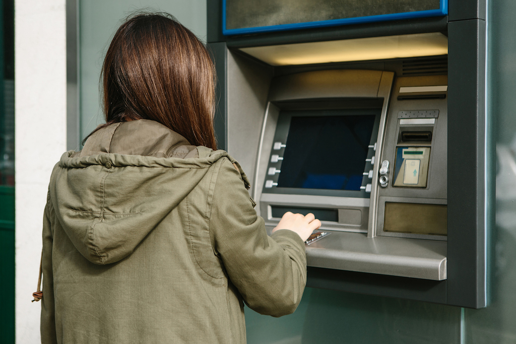 Woman withdraws money from an ATM