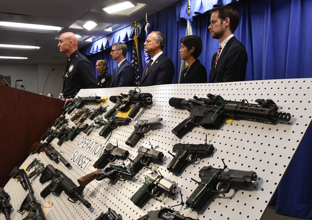 LAPD and FBI representatives display weapons seized after a raid