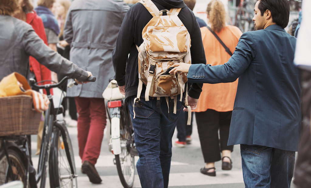 Pulls wallet out of a man's backpack