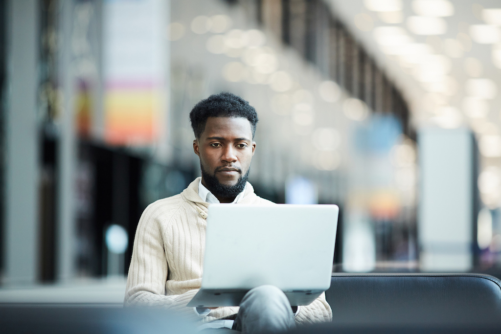 Man on laptop at airport