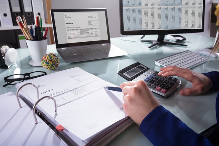 Businessperson checking numbers on a calculator
