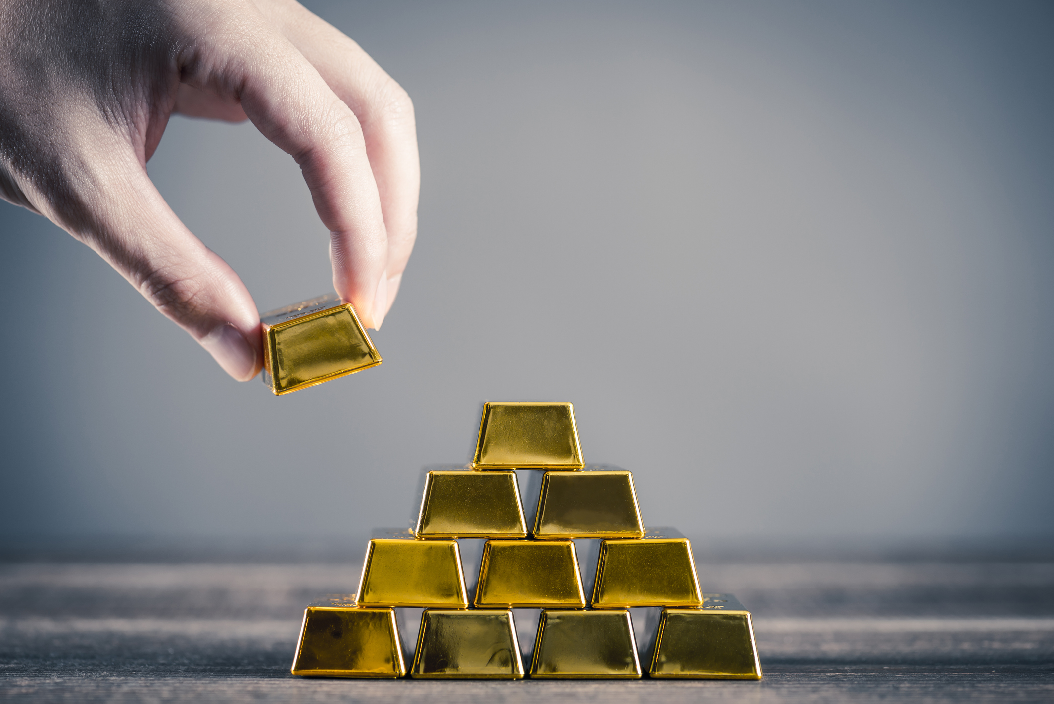 Hand grabbing a gold bar