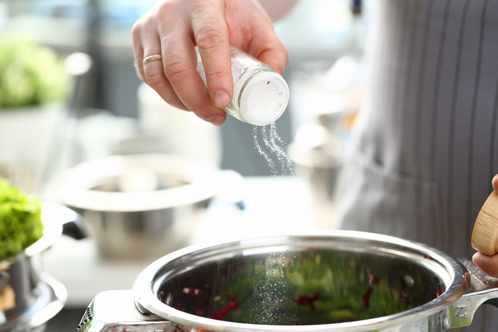Man adding salt to food