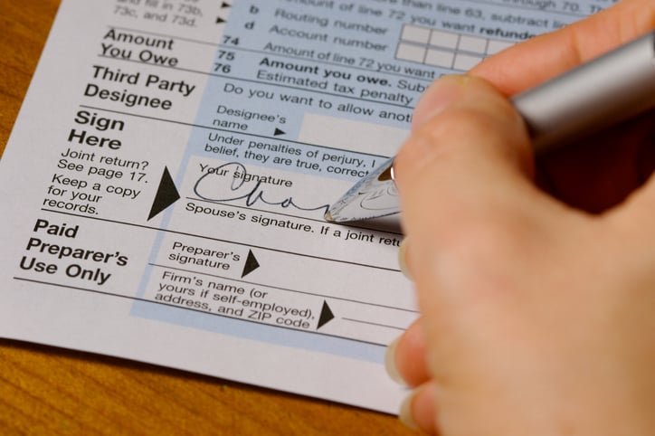 Close up of someone signing a tax form