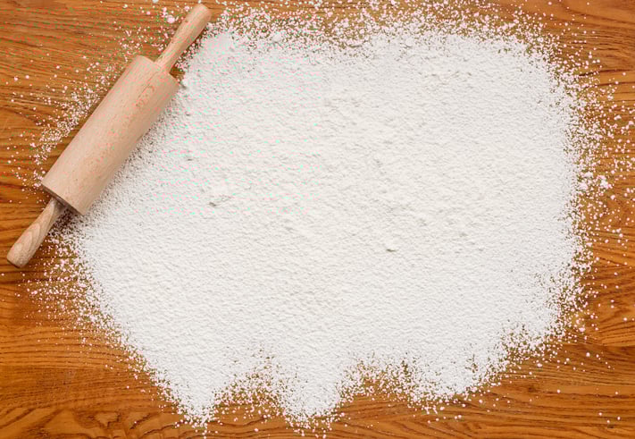 Bleached white flour on a table with a rolling pin