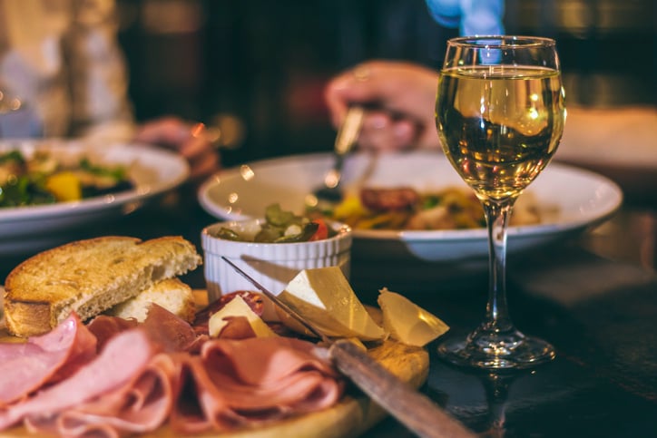 A glass of wine and a restaurant meal