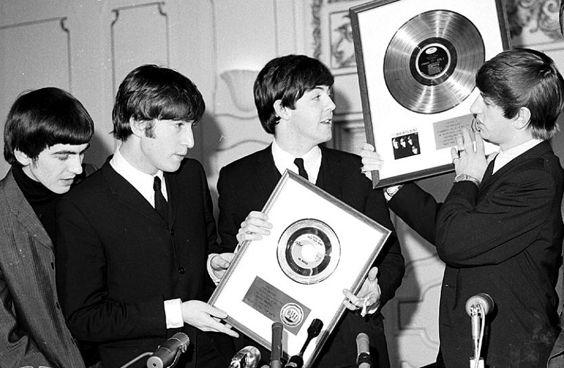 The Beatles celebrate gold records.