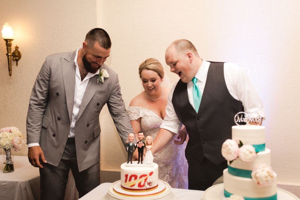 Kelce helping cut the wedding cake