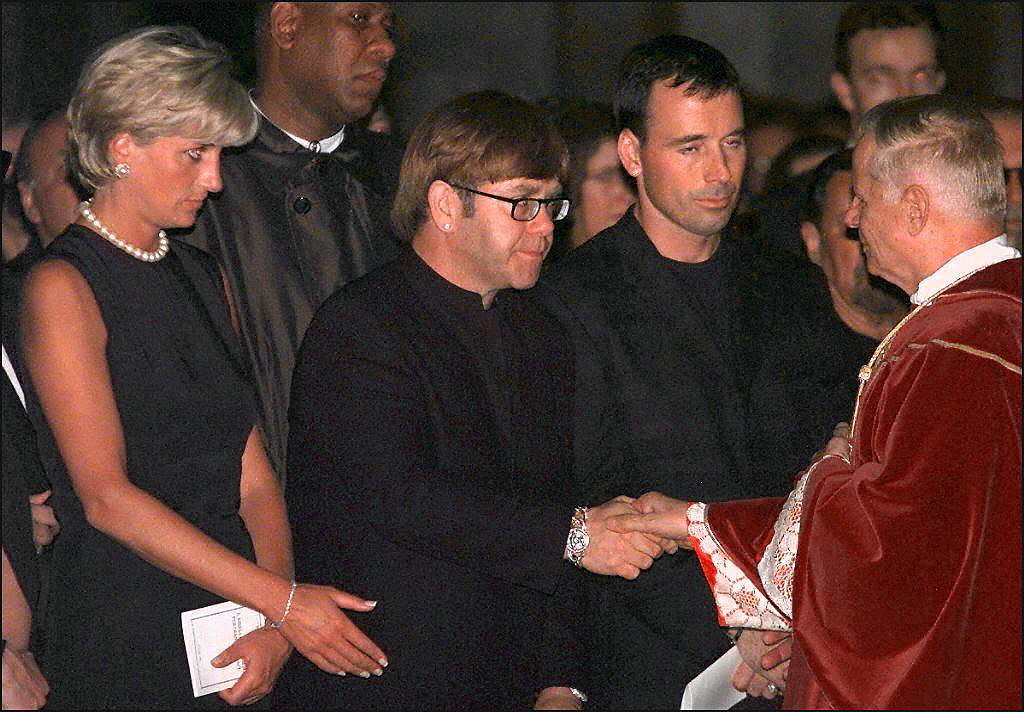 The late Princess Diana stands next to singer Elton John at the funeral mass for Gianni Versace