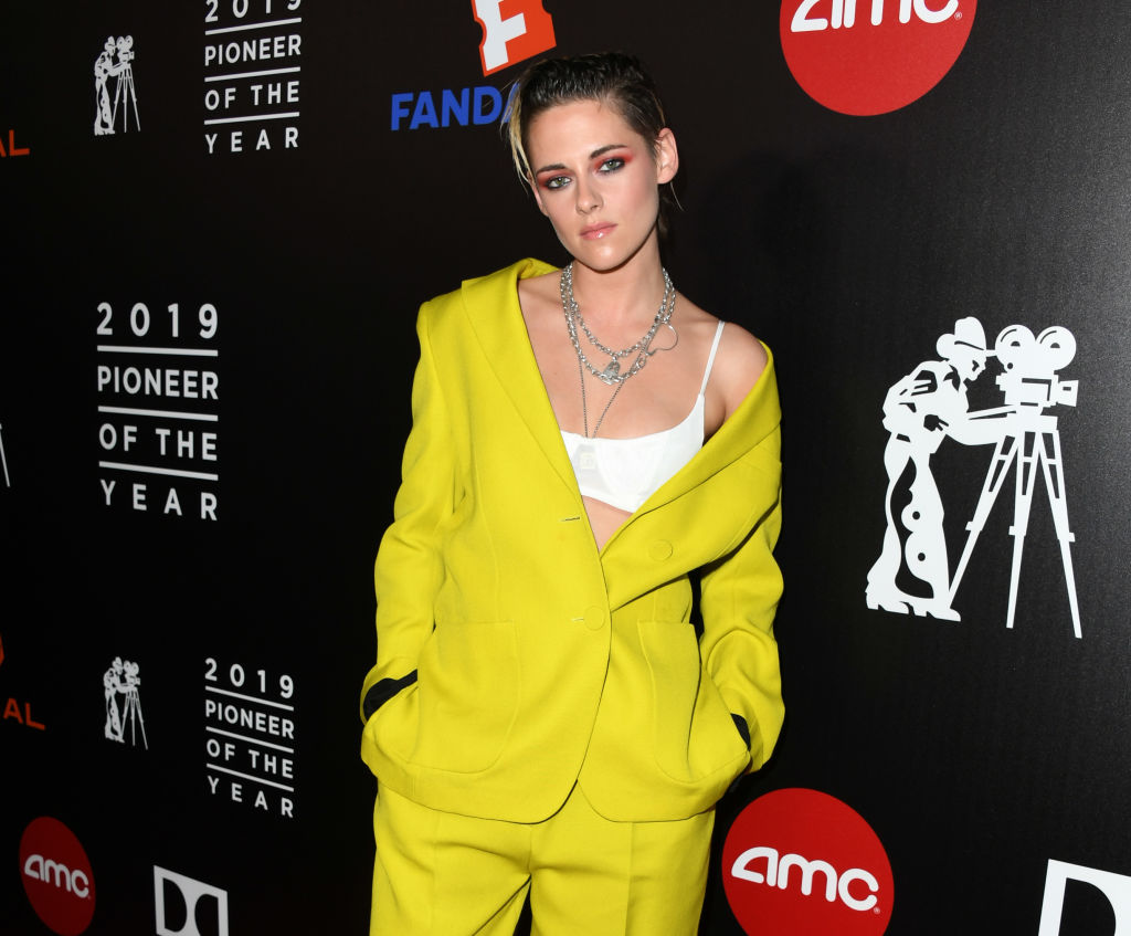 Kristen Stewart poses on the red carpet in an oversized, bright yellow suit