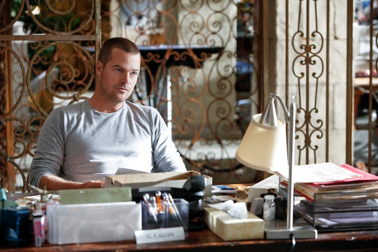 Chris O'Donnell sitting at a desk in Chris O'Donnell in NCIS: Los Angeles
