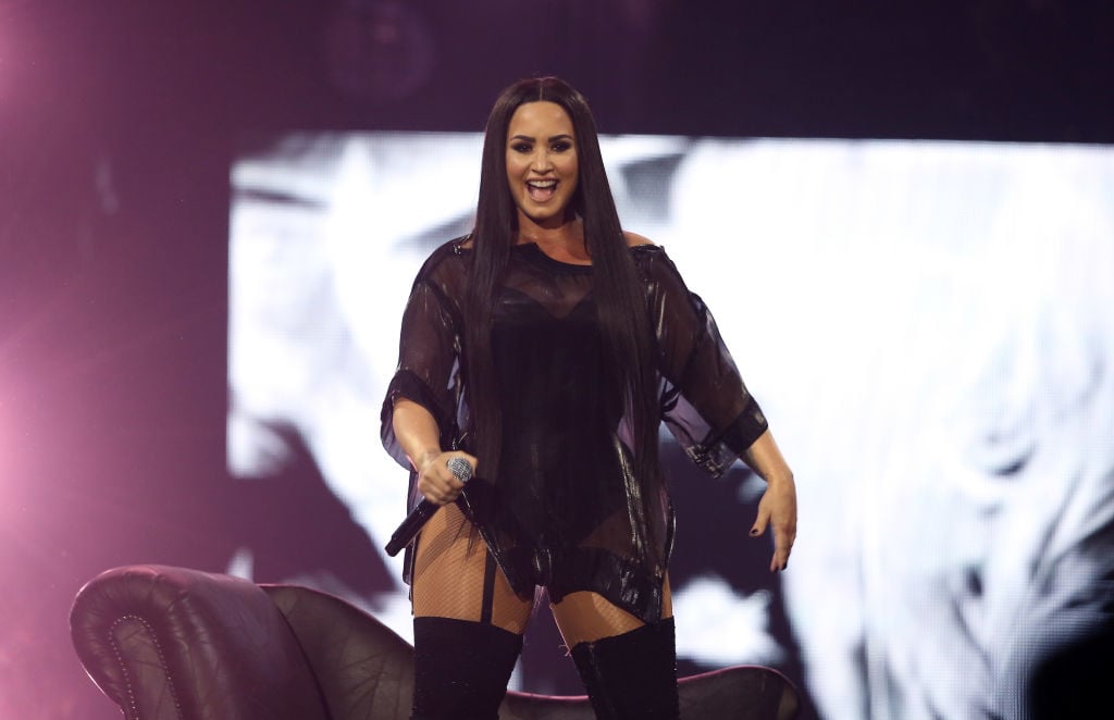 Demi Lovato smiling on stage while performing at the O2 Arena