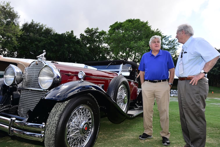 Jay Leno: Stop Believing This Myth About Used Cars - Showbiz Cheat Sheet 1 Jay Leno standing next to a car