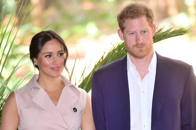 Prince Harry and Meghan Markle stand together smiling