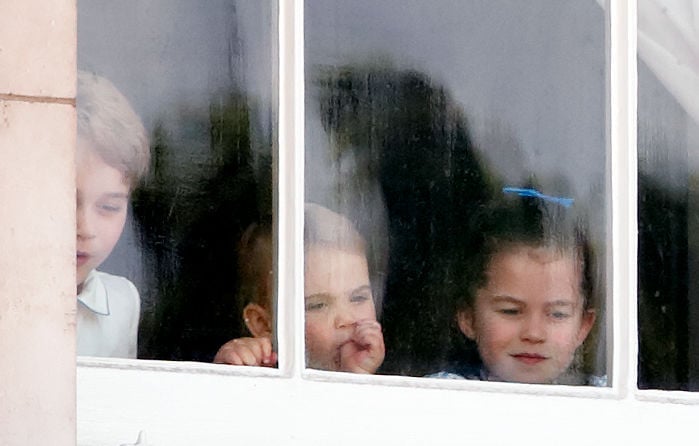 Prince George, Prince Louis, and Princess Charlotte looking through a window