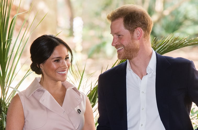 Prince Harry and Meghan Markle smiling at each other