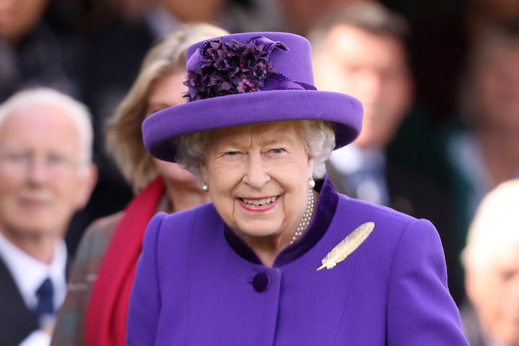 Queen Elizabeth II in a purple outfit and hat
