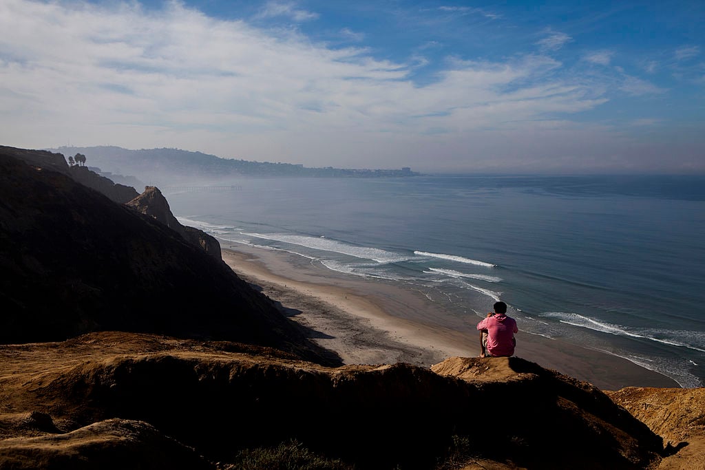 A visitor looks out over Blacks Beach in San Diego, California