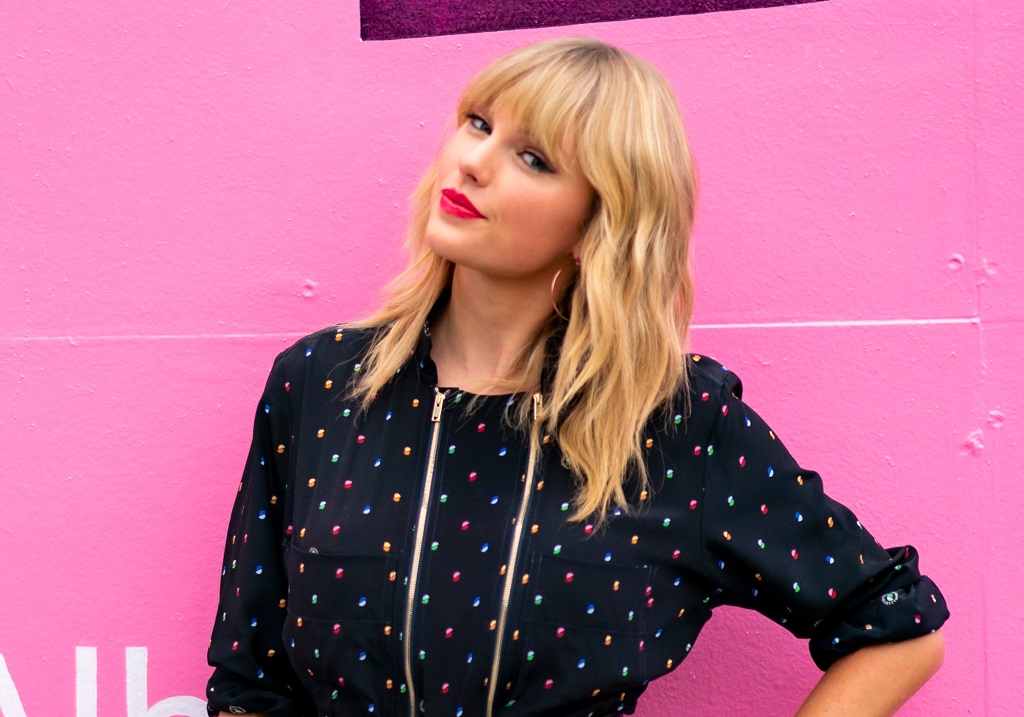 Taylor Swift poses in front of a mural for 'Lover' on August 23, 2019