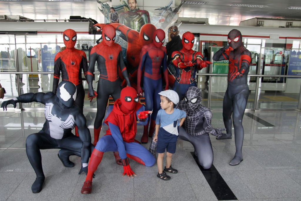 A group of cosplayers dressed as various versions of Spider-Man. 