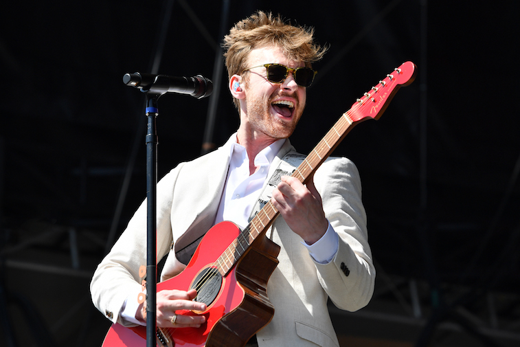 Finneas O'Connell plays guitar onstage