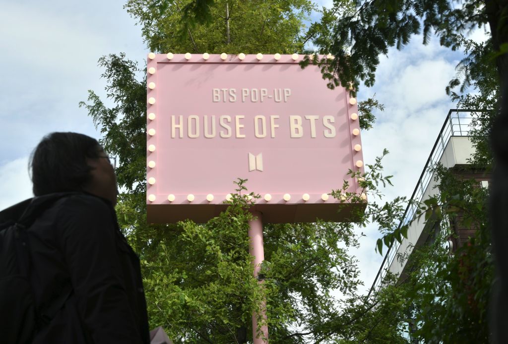 A fan of South Korean K-pop boy band BTS stands outside a BTS pop-up store in Seoul