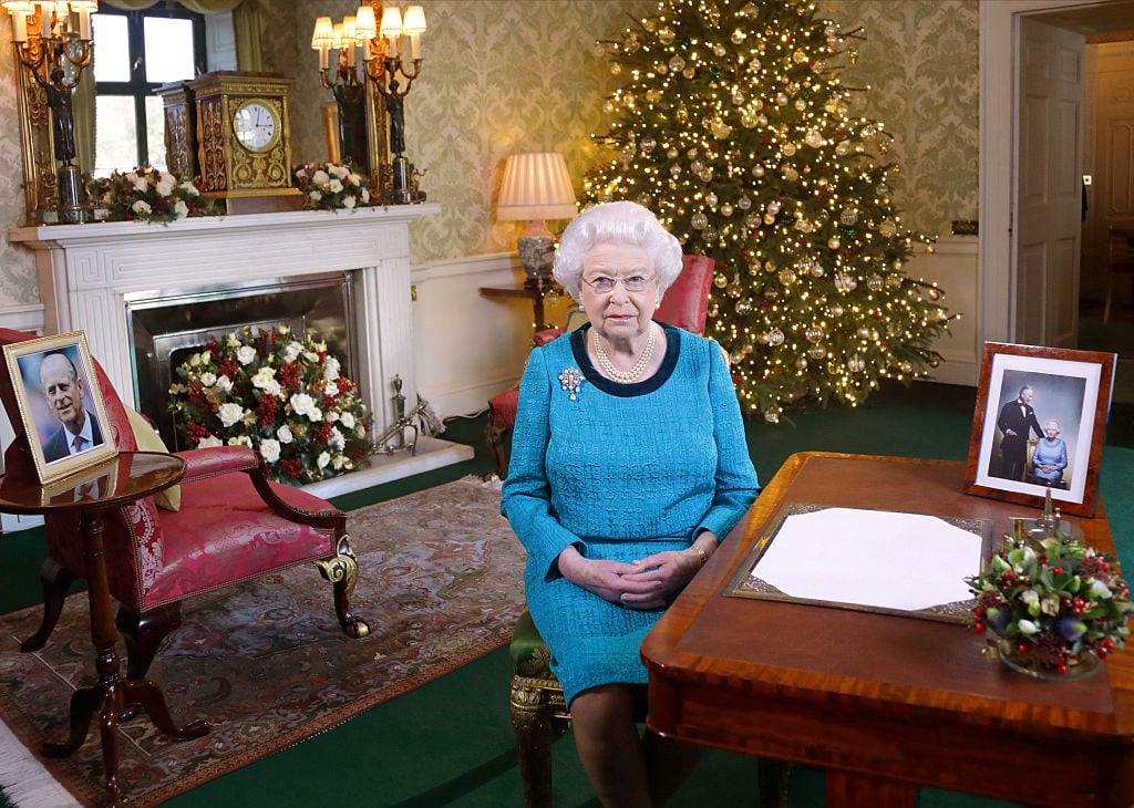 Queen Elizabeth II sits at a desk in the Regency Room.