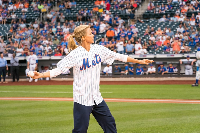 Tea Leoni throws a pitch at a baseball game